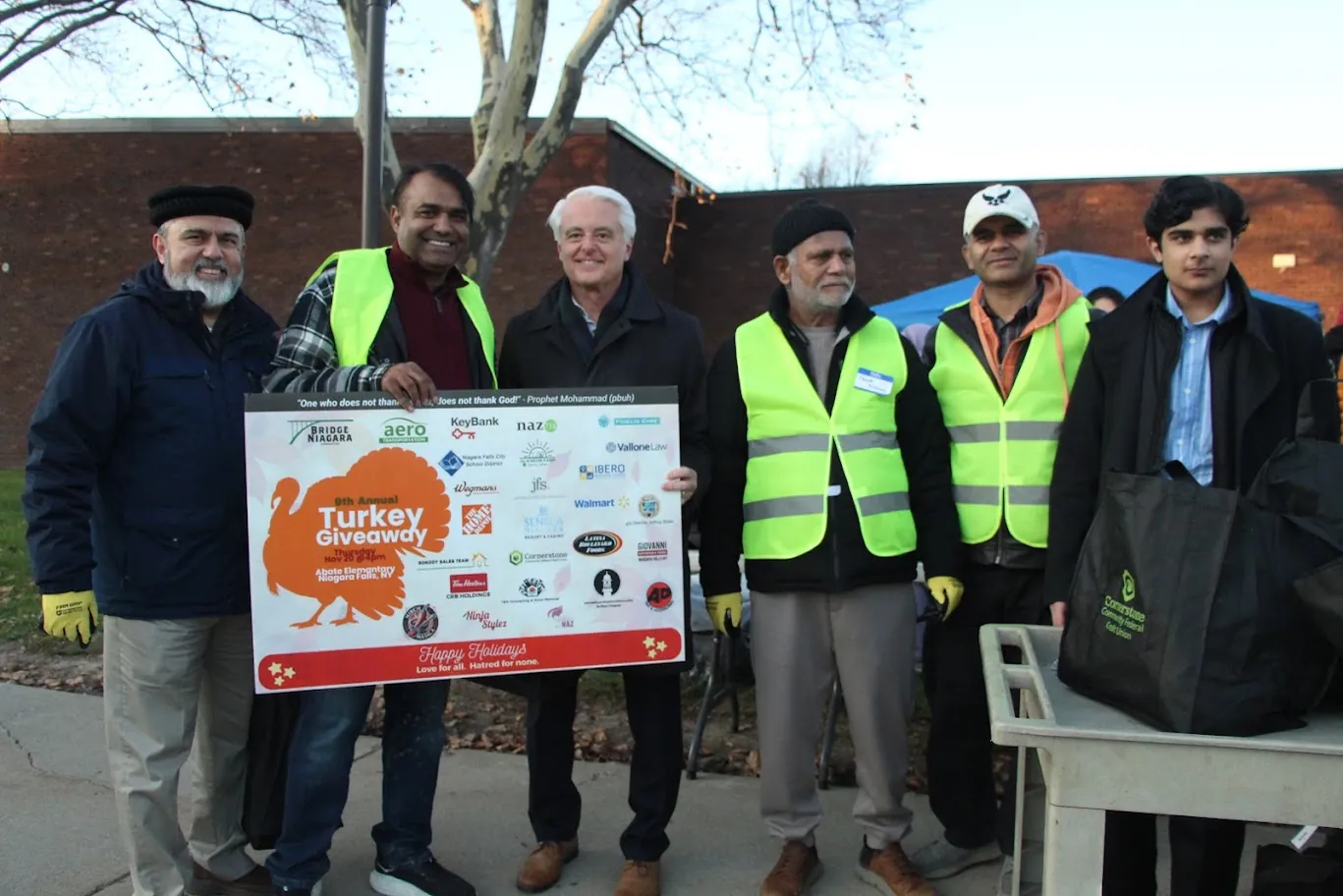 Community organizers and volunteers stand together at a past Turkey Giveaway