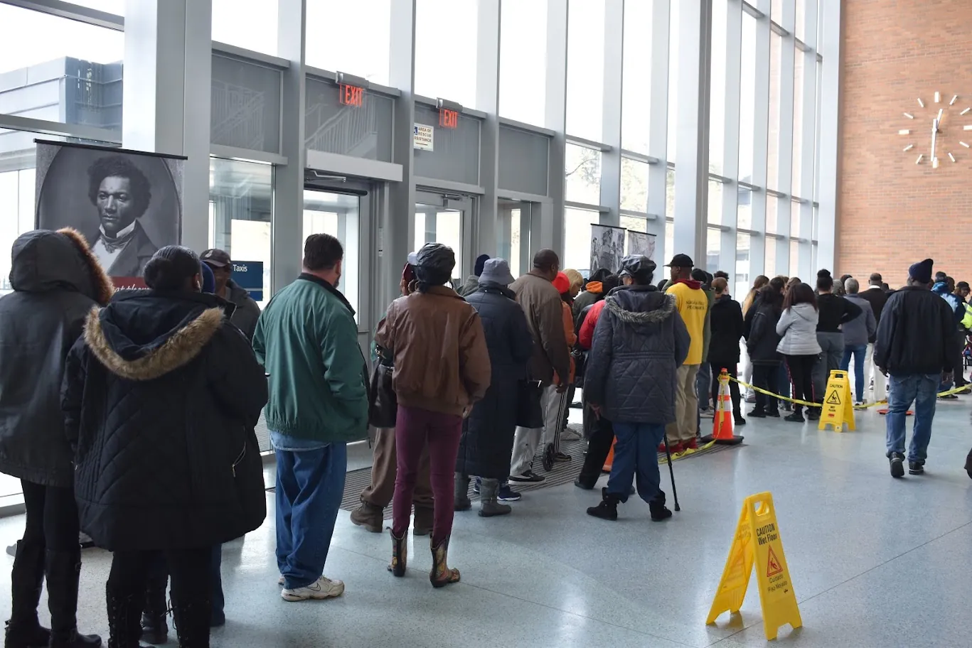 Community members wait in an organized line inside a public venue during a past Turkey Giveaway