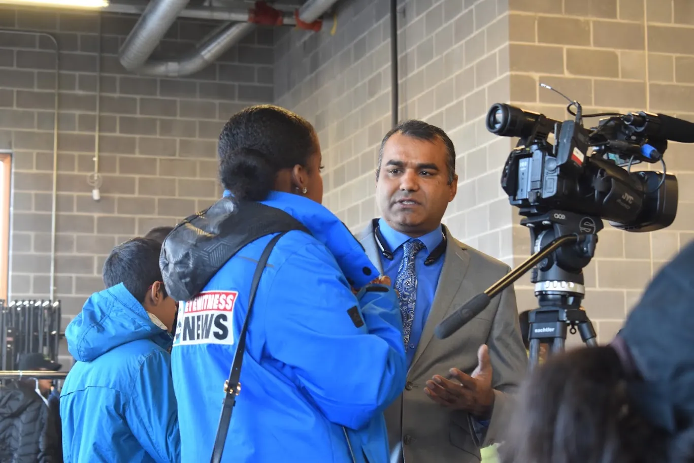 A local television reporter interviews a Turkey Giveaway organizer at a past event